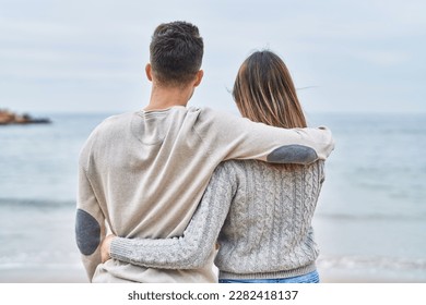 Man and woman couple hugging each other on back view at seaside - Powered by Shutterstock