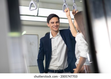 Man And Woman Couple Passengers Talking On Urban Public Transport Metro. Business People Go To Work By Public Transport