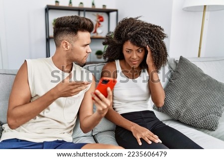 Man and woman couple with problems using smartphone at home