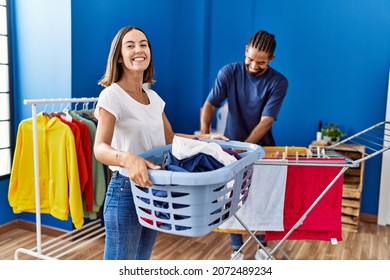 Man and woman couple smiling confident hanging clothes on clothesline at laundry
