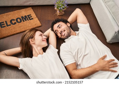 Man And Woman Couple Smiling Confident Lying On Floor At New Home