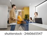 Man and woman couple talking to receptionist at family clinic center