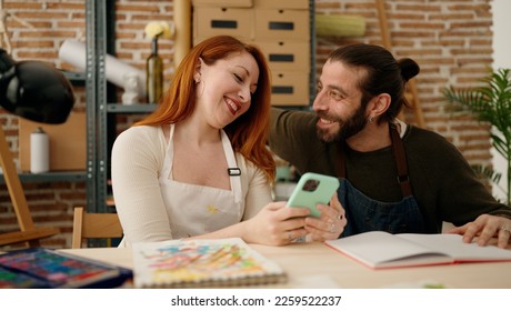 Man   woman couple using smartphone   drawing at art studio