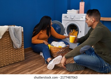 Man And Woman Couple Washing Clothes Drinking Coffee At Laundry Room