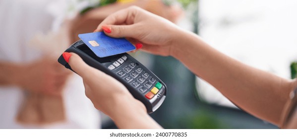 Man and woman customer buying bouquet of flower by credit card at flower shop - Powered by Shutterstock