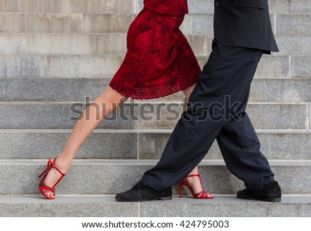 man and woman dancing tango on street staircase