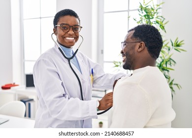 Man and woman doctor and patient having medical consultation auscultating chest at clinic - Powered by Shutterstock