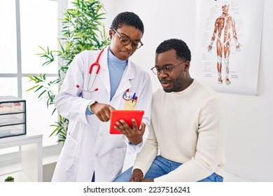 Man and woman doctor and patient having medical consultation using touchpad at clinic - Powered by Shutterstock