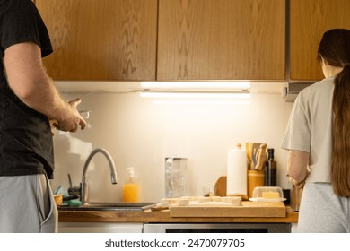 Man and woman doing dishes together in kitchen. Young couple making Breakfast together. Concept of gender equality. - Powered by Shutterstock