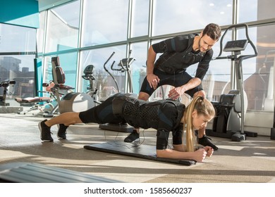 Man and woman doing electro muscular stimulation training in a modern gym