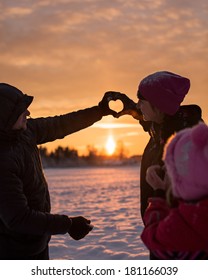 Man And Woman Doing Heart Hands In Winter At Sunset