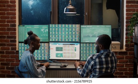 Man And Woman Doing Teamwork On Financial Stock Market Statistics Funds, Using Multi Monitor Workstation. Real Time Stocks Changing, Forex Exchange Prices To Create Trading Profit.