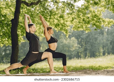 Man and woman doing yoga exercises in the park - Powered by Shutterstock