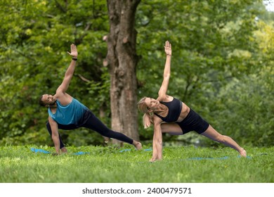 Man and woman doing yoga exercises in green park. - Powered by Shutterstock