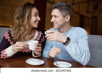 Man and woman drinking coffee in a cafe. Two people, man and woman in cafe communicate, laughing and enjoying the time spending with each other. Couple in love on a date. Love story and Valentines Day - Powered by Shutterstock