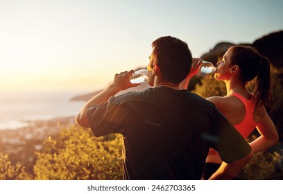 Man, woman and drinking water or mountain exercise for workout break with sunset, view or journey. Couple, relax and ocean horizon for hiking rest or evening trekking as adventure, training or cardio - Powered by Shutterstock