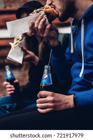 Man And Woman Eating Burgers And Holding Pepsi