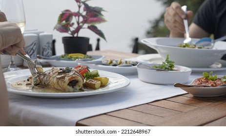 Man And Woman Eating At Seaside Restaurant