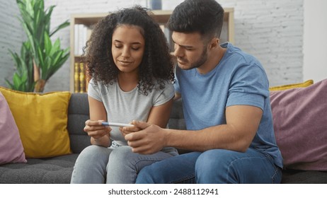 A man and woman examine a pregnancy test together on a sofa in a cozy living room setting. - Powered by Shutterstock