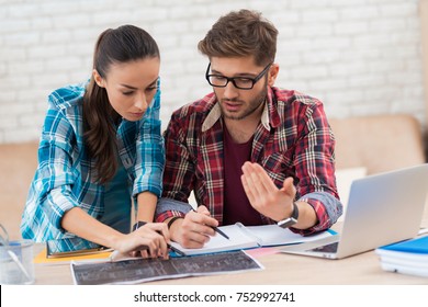 A man and a woman are examining the scheme. They are students and do homework from the teacher. The diagram shows the details. They have ballpoint pens in their hands.
