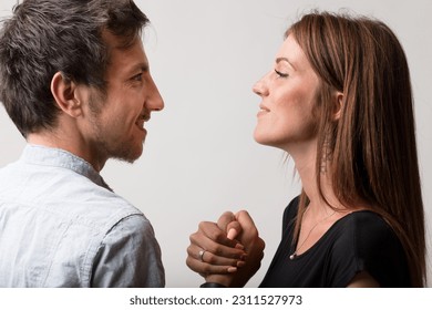 A man and woman face off in playful defiance, challenging each other to an arm wrestle. Symbolizing male versus female, both as friends, lovers, and rivals, they maintain a sense of pride and fun whil