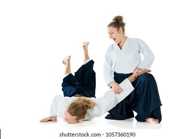 Man and woman fighting at Aikido training in martial arts school. Healthy lifestyle and sports concept. Man with beard in white kimono on white background.