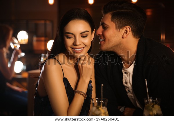 Man and woman\
flirting with each other in\
bar