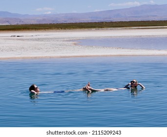 Man and woman floating and relaxing in salt laguna ceja in Atacama