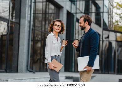 Man And Woman Going On Stairs In Urban City Center In Smart Casual Business Style, Talking, Working Together, Smiling, Stylish Freelance People, Holding Coffee And Laptop, Discussing