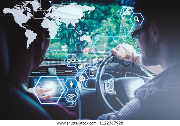 A man\
and woman with graphical user interface(GUI) in vehicle.System\
control pushing panel button,Internet of Things(IOT),Intelligent\
car,Transportation,technology and vehicle\
concept