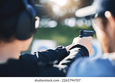 Man, woman and gun training with target, outdoor challenge and aim at police, army or security academy. Shooting coach, pistol or firearm for sport, safety and combat exercise in nature with vision