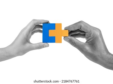Man and woman hands with two matching puzzle pieces isolated on white background. Partnership, connection concept. Mutual understanding, support in relations. High quality photo