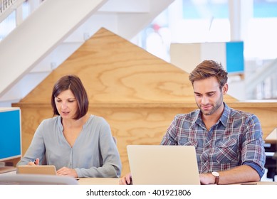 Man And Woman Hard At Work Next To Each Other