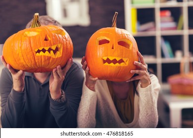 Man and woman having fun with Halloween pumpkin