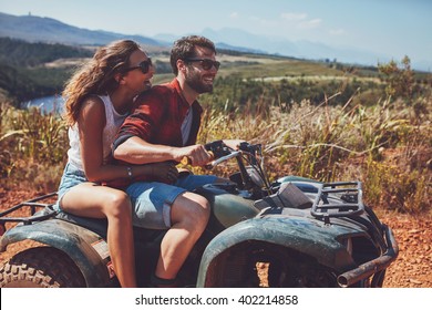 Man and woman having fun on an off road adventure. Couple riding on a quad bike in countryside on a summer day. - Powered by Shutterstock