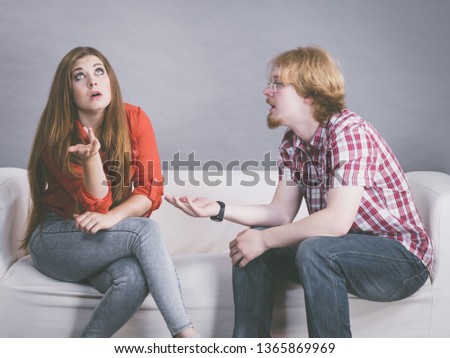 Man and woman having horrible fight while sitting on sofa. Friendship, couple breakup difficulties and problems concept.