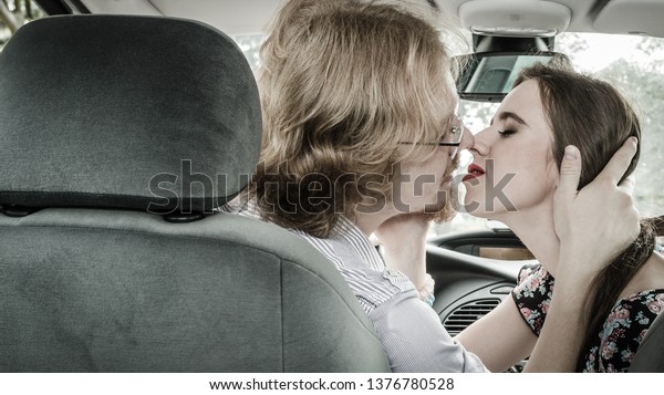 Man and woman having\
romance. Couple kissing with passion in car, view from inside.\
Relationship concept.