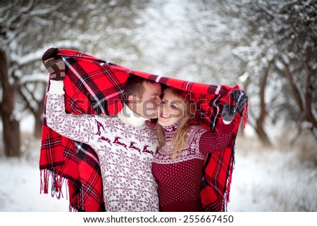 man and woman is heated under a blanket in winter