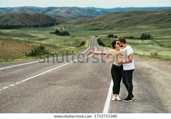 A\
man and a woman are hitchhiking. A young couple goes hitchhiking\
around the country. Free hitchhiking trip. A lover who travels free\
by hitchhiking. The couple goes traveling. Copy\
space