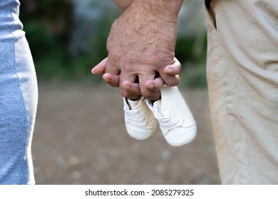 man and woman holding baby shoes. Couple expecting a baby