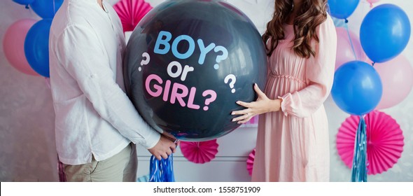 man and woman holding black balloon with "boy or girl?" on gender reveal party - Powered by Shutterstock