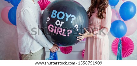 man and woman holding black balloon with 'boy or girl?' on gender reveal party Foto stock © 