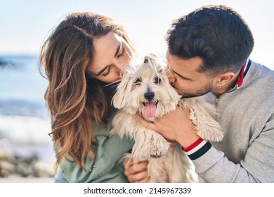 Man and woman holding dog hugging each other kissing at seaside - Powered by Shutterstock