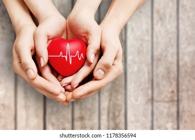 Man And Woman Holding Red Heart In