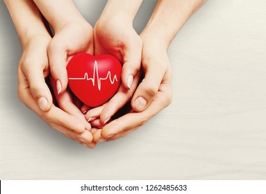 Man and woman holding red heart in