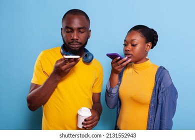 Man And Woman Holding Smartphone To Record Message On Microphone Speaker In Studio. Modern Couple In Relationship Using Mobile Phone To Make Online Speech And Have Internet Conversation.