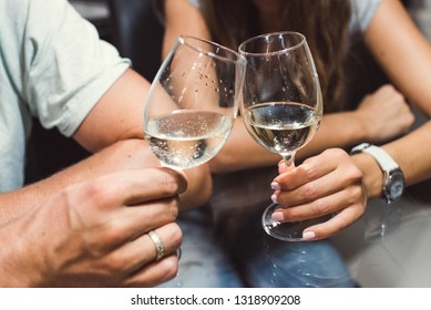 A man and a woman are holding wine glasses in their hands.