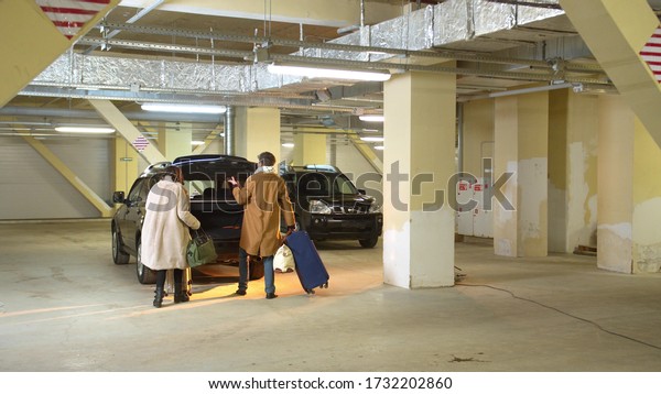 Man and a\
woman in a hurry stack luggage in a\
car