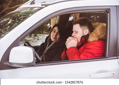 Man And Woman Inside Car In Winter Clothes.