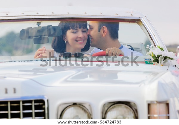man and woman\
kissing in the car front\
view
